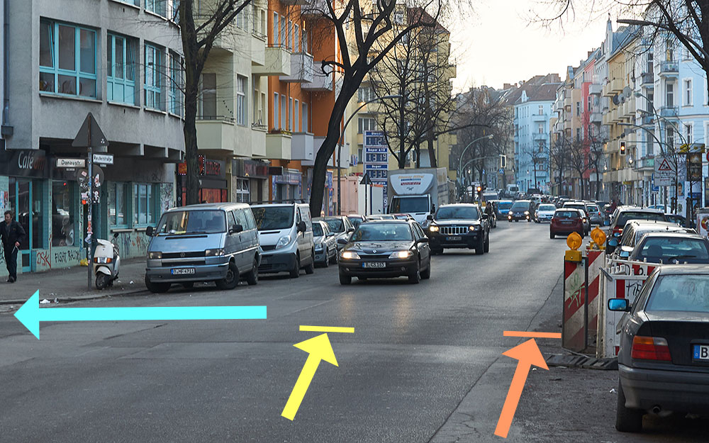 Foto mit Skizze: Reuterstraße Abbiegemöglichkeiten mit Fahrrad in die Donaustraße, Sicht von rechter Fahrbahnseite.
