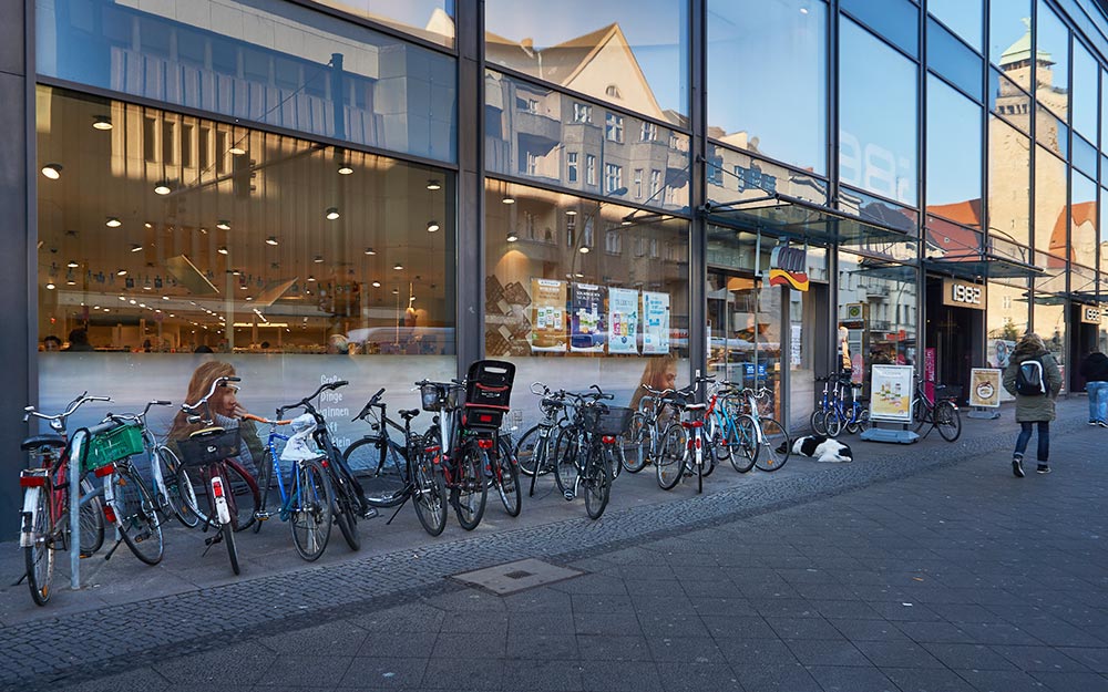 Foto: Voll belegte Fahrradständer vor einem Drogeriemarkt in der Karl-Marx-Straße.