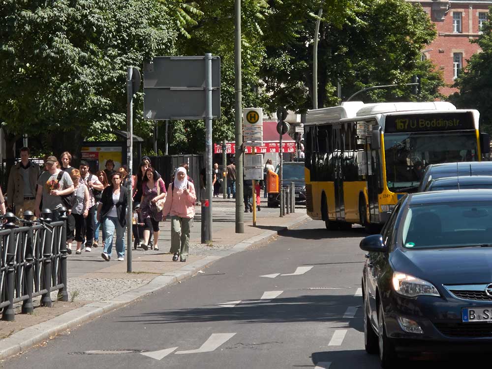 Foto: Blick von der Karl-Marx-Str. in die Erkstr. mit abfahrendem Bus der Linie 167, der sich in den Linksabbiegerstau einreihen muss.